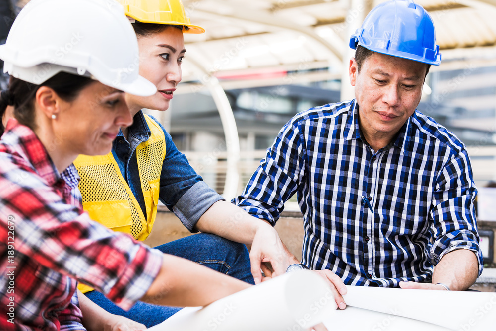 Engineers man and woman working on plan building construction in city Engineers man and woman working on plan building construction in city