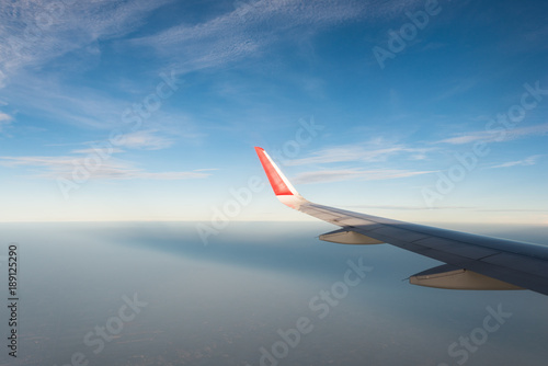 Wing of an airplane in morning sunrise .