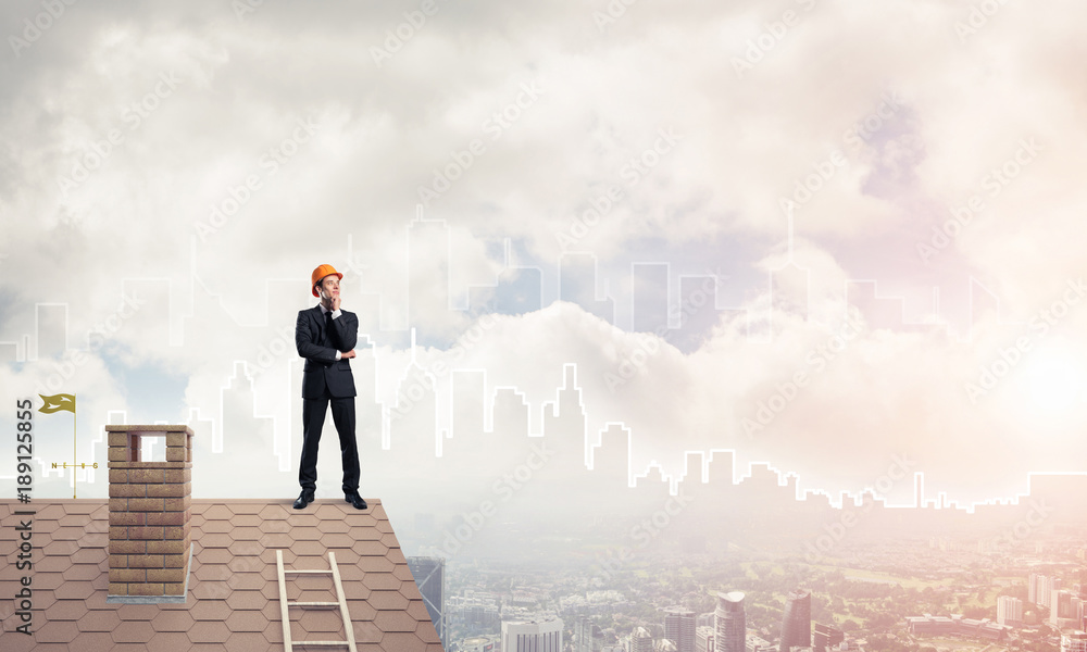 Engineer man standing on roof and looking away. Mixed media Engineer man standing on roof and looking away. Mixed media