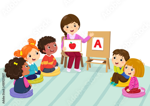 Group of preschool kids and teacher sitting on the floor.Teacher explaining alphabet to children