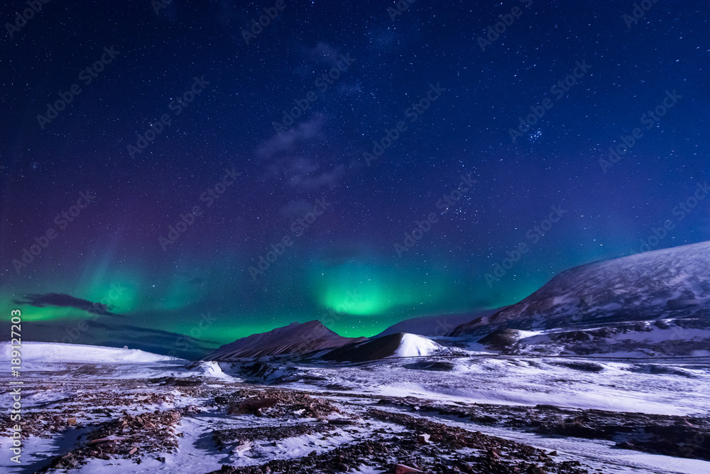 The polar arctic Northern lights aurora borealis sky star in Norway Svalbard in Longyearbyen city town mountains