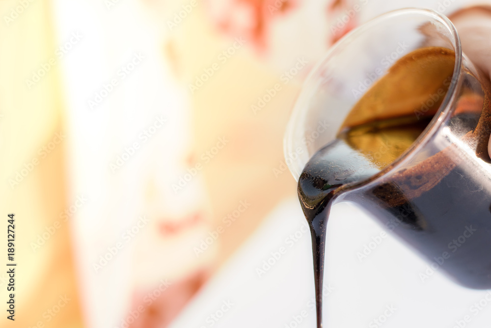 Molasses sugarcane on beaker. Droping molasses with hands. Molasses is the final product from