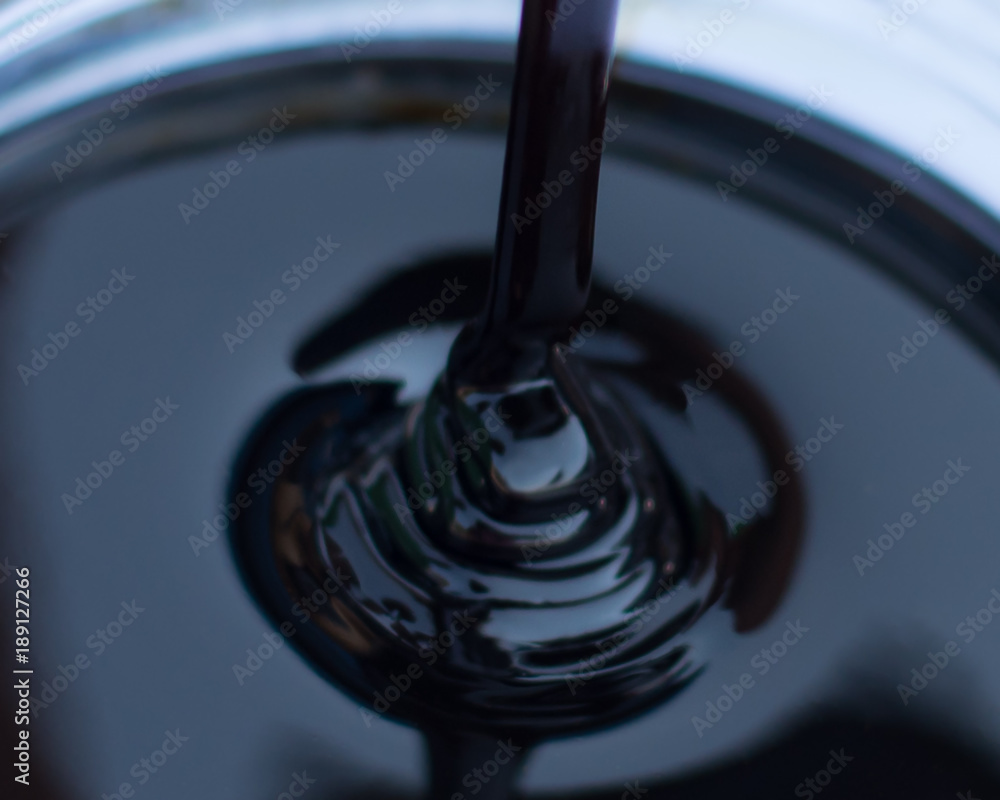Molasses sugarcane on beaker blurred style background. Droping molasses
