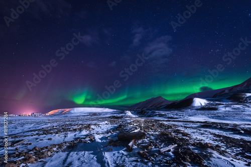 Fototapeta Naklejka Na Ścianę i Meble -  The polar arctic Northern lights aurora borealis sky star in Norway Svalbard in Longyearbyen city town mountains