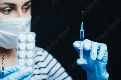 girl in mask with syringe and pills