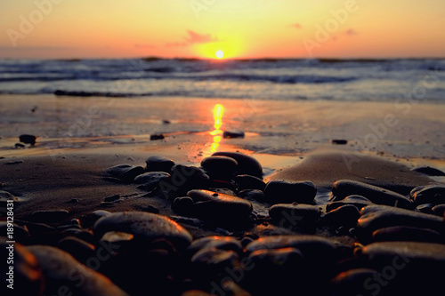 Small stones on the beach at sunset