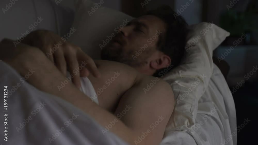Drunken man sleeping on couch dreaming something bad, having hiccups in sleep Drunken man sleeping on couch dreaming something bad, having hiccups in sleep