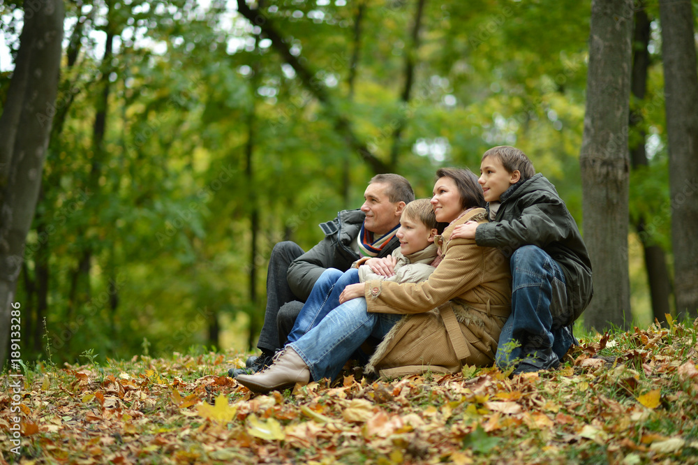 Happy smiling family sitting on leaves Happy smiling family sitting on leaves