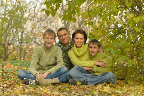 smiling family in autumn forest 