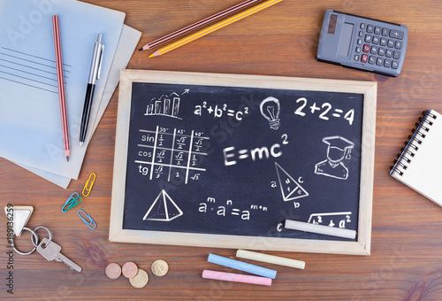 math formulas, education and knowledge concept. Chalkboard on wooden office desk.