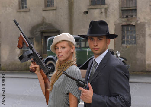 Two models get dressed up in 1930's style  vintage fashion clothes and act the role of  the gangster duo Bonnie and Clyde.