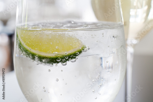 Close up of water glass with ice and lime