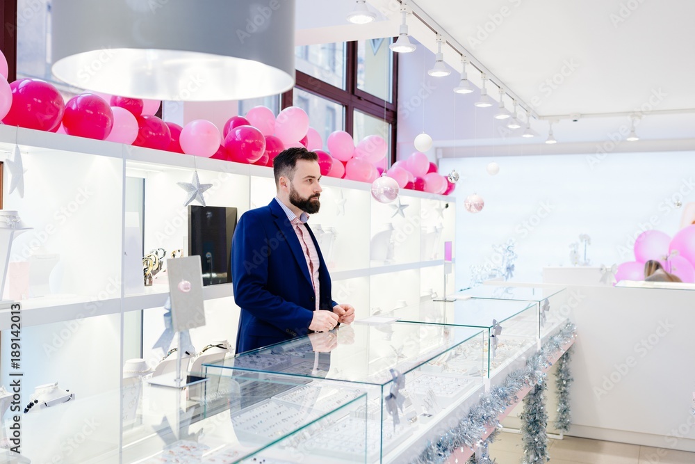 Attractive man with a beard is standing behind the counter