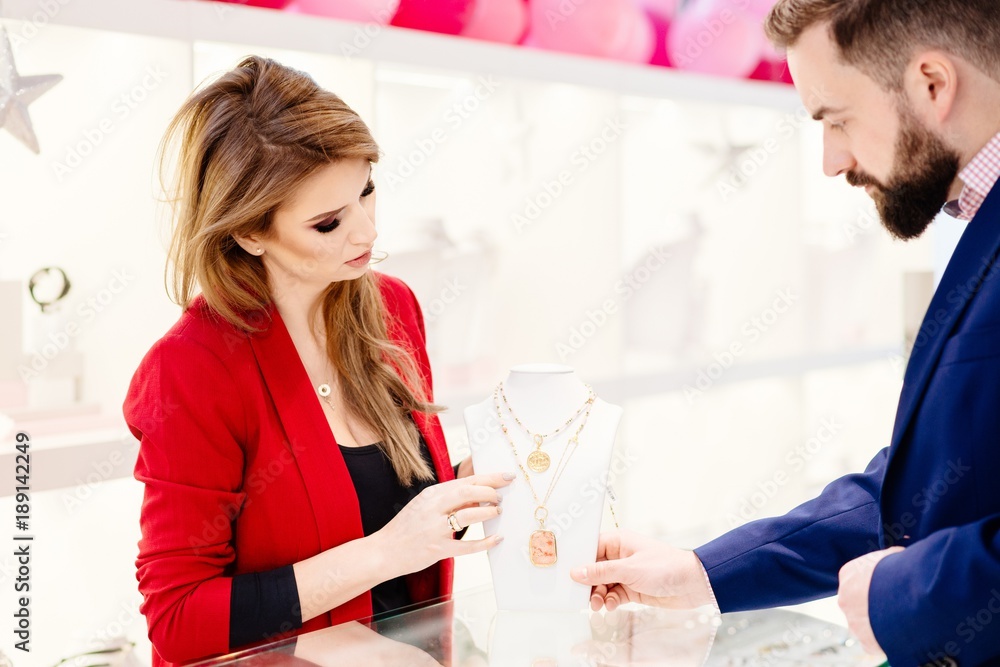 Attractive man with a beard choosing a valentine's day gift in jewelry store Attractive man with a beard choosing a valentine's day gift in jewelry store