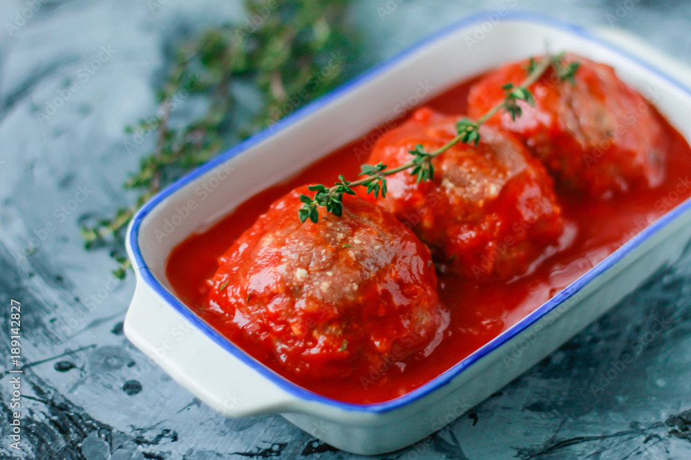 Raw meatballs from beef in tomato sauce with thyme Raw meatballs from beef in tomato sauce with thyme