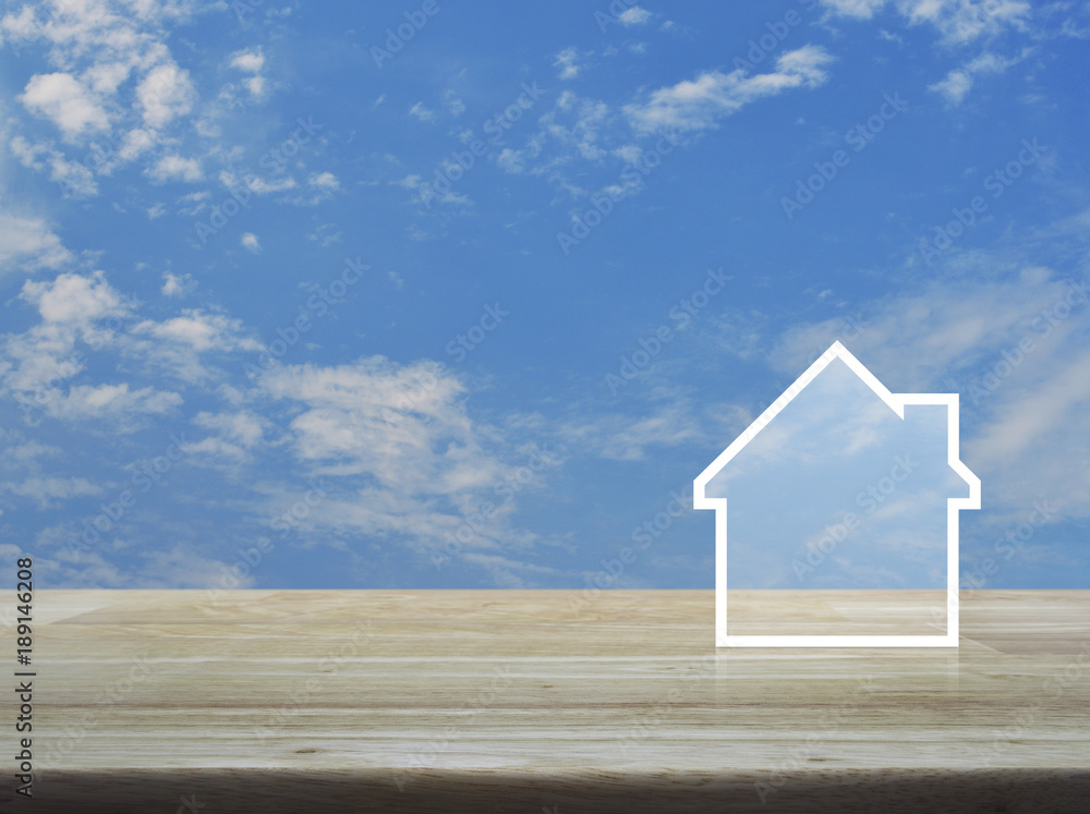 House icon with copy space on wooden table over blue sky with white clouds, Real estate concept