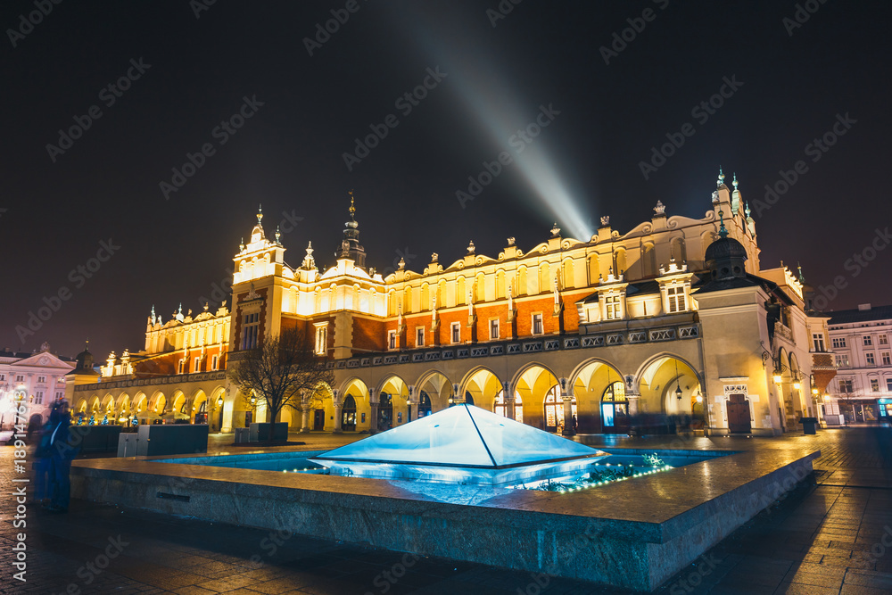 Obraz premium Cloth Hall building and fountain at night on main square of Krakow city, Poland