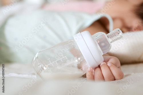 Baby sleeping after drinking bottle milk , Close up of bottle of milk , Baby sleep with a bottle of milk