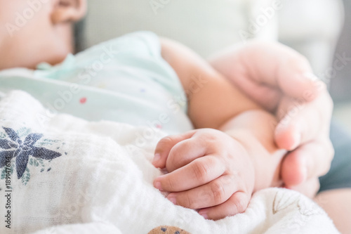 Hand the sleeping baby in the hand of mother soft focus, love and family concept