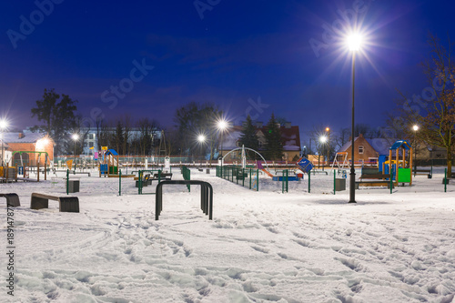 Snowy winter at the playground at dusk, Poland