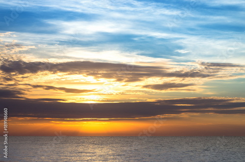 sea horizon, a beautiful evening sky with clouds, the sun is behind the clouds, the waves on the water. Background.