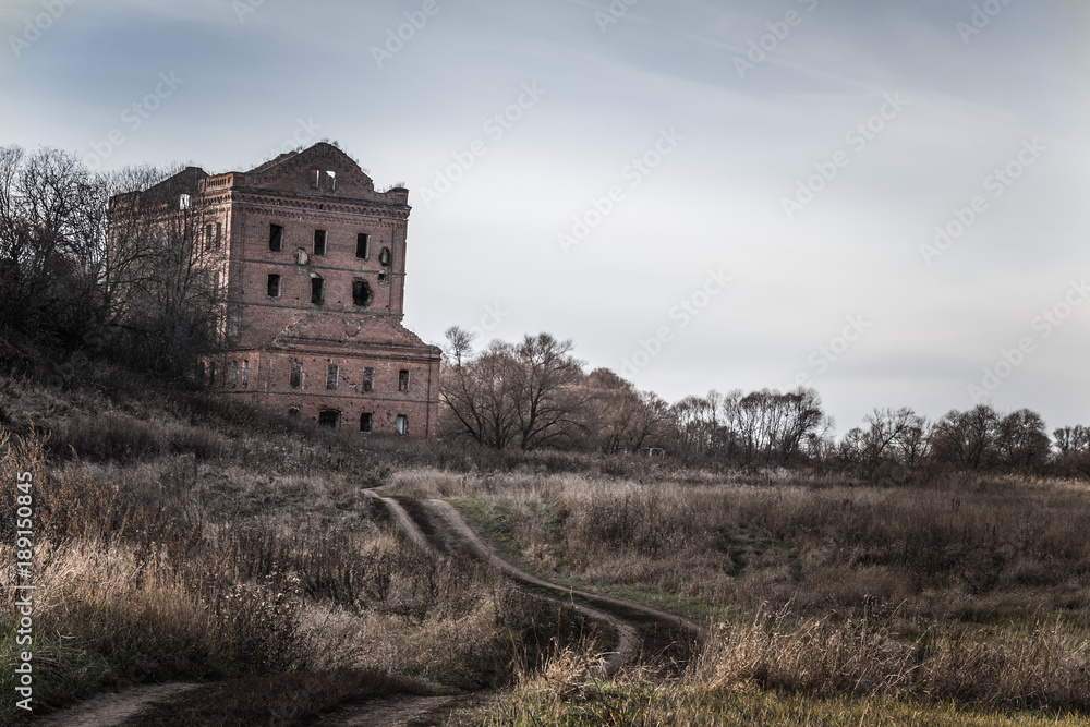 Old destroyed mill on an autumn landscape. Toned