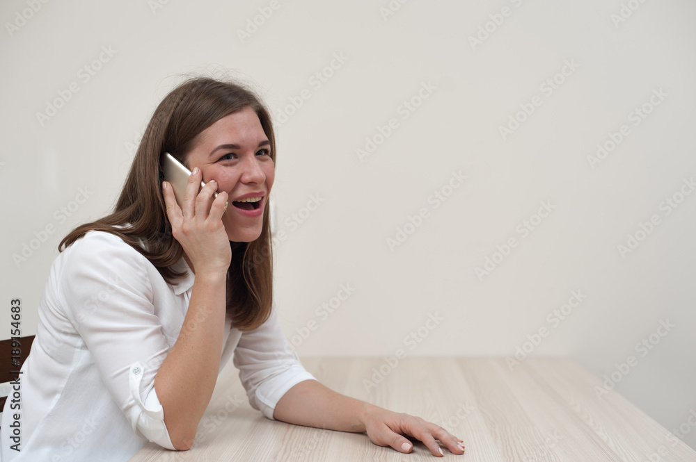 Portrait of successful businesswoman talking on smartphone on white wall background Portrait of successful businesswoman talking on smartphone on white wall background