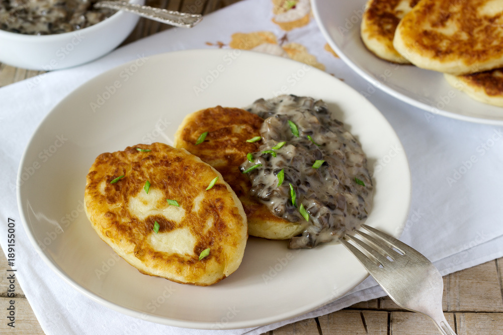 Potato cutlets or pancakes with mushroom sauce and green onions. Rustic style.