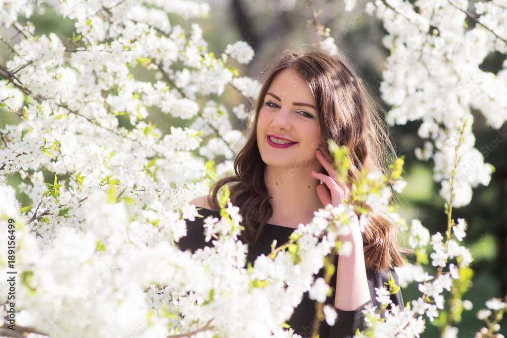 Beautiful young girl in the park in the spring.