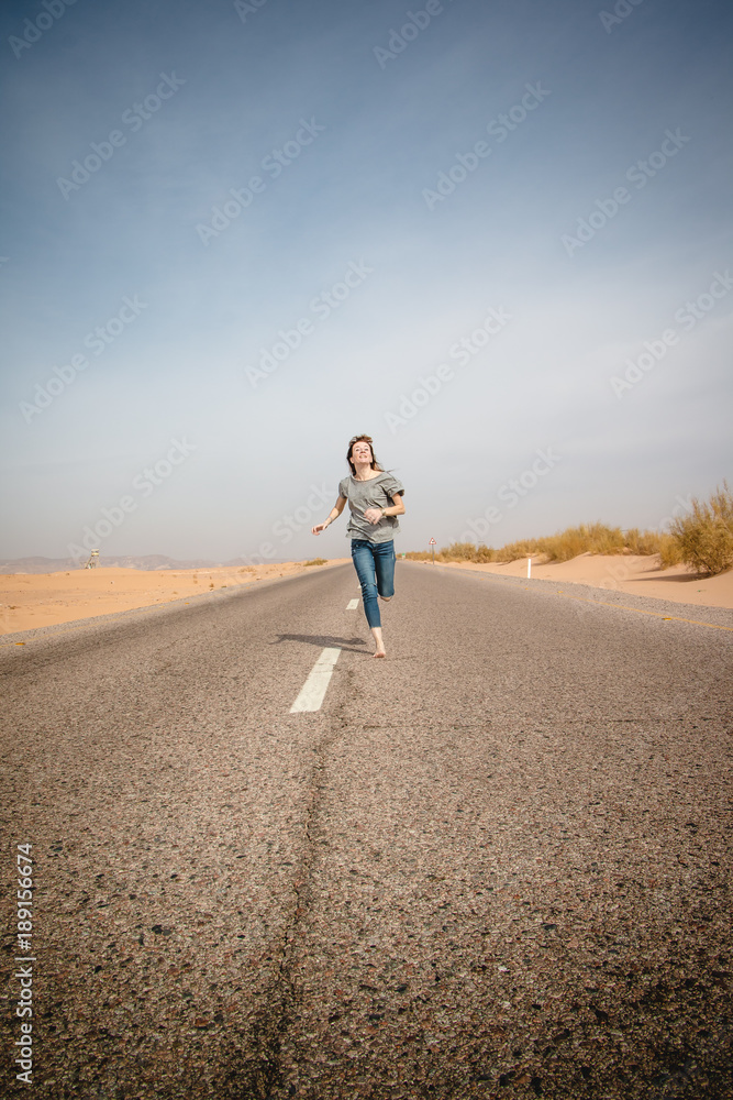 Obraz premium Girl have fun on the road in a desert