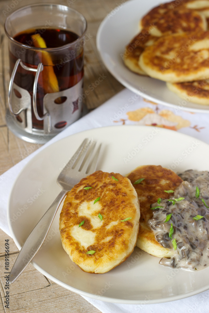 Potato cutlets or pancakes with mushroom sauce and green onions. Rustic style.