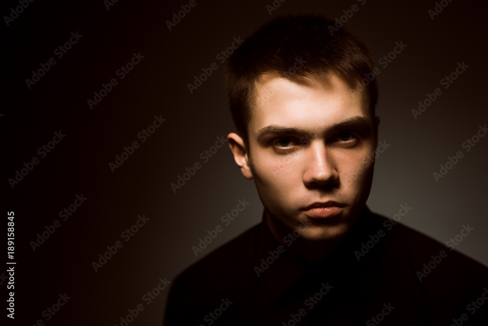 young guy on a dark studio background young guy on a dark studio background