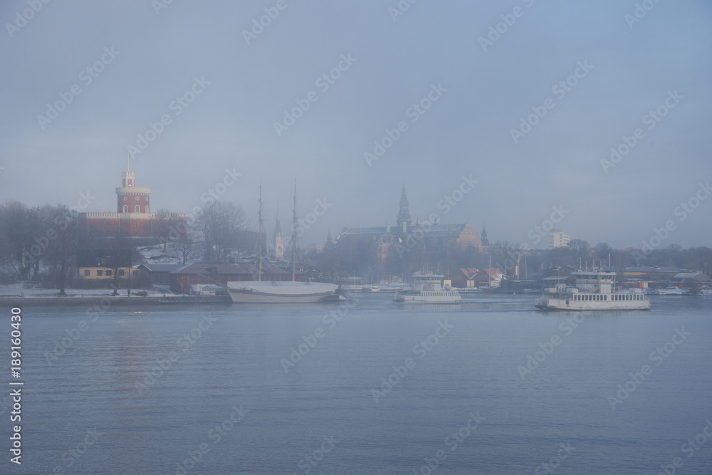 Foggy winter morning at the waterfront of Stockholm with a ferry landmarks
