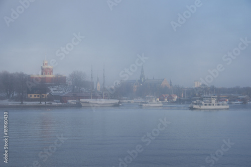 Foggy winter morning at the waterfront of Stockholm with a ferry landmarks