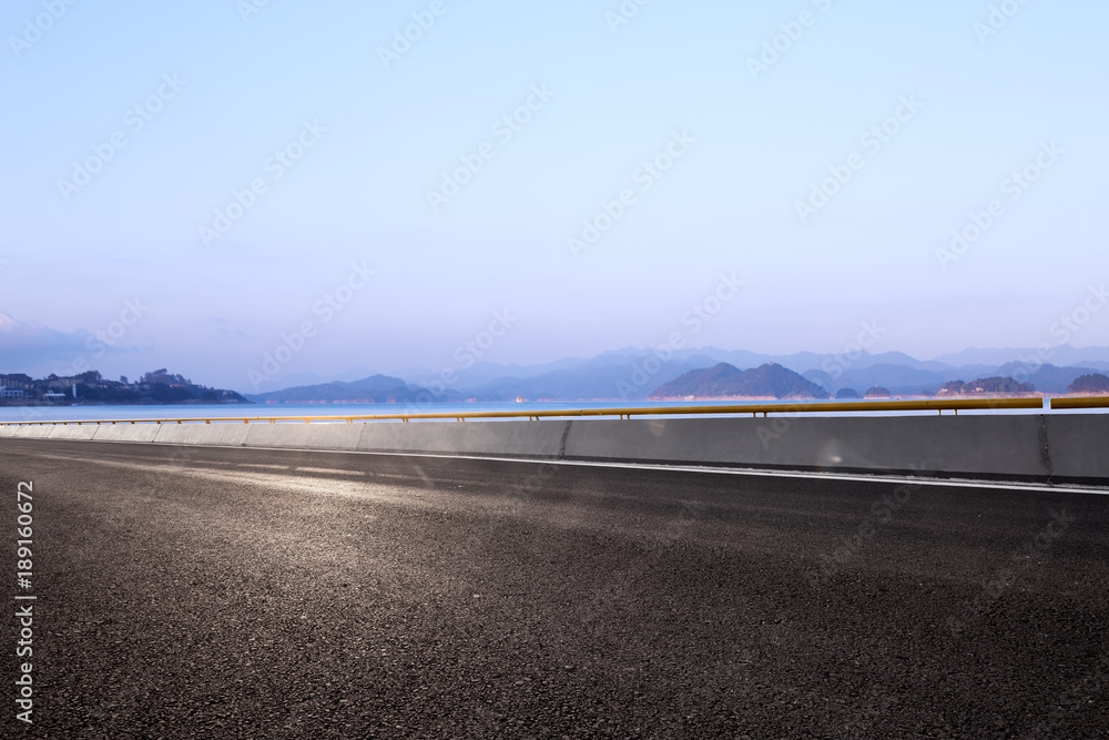 Fototapeta premium empty asphalt road with beautiful lake