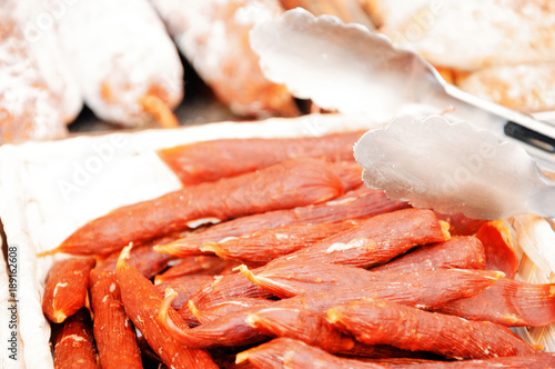 Dry sausage for sale at Red Children Market ("Marche des Enfants Rouges") in Paris (France). Selective focus.