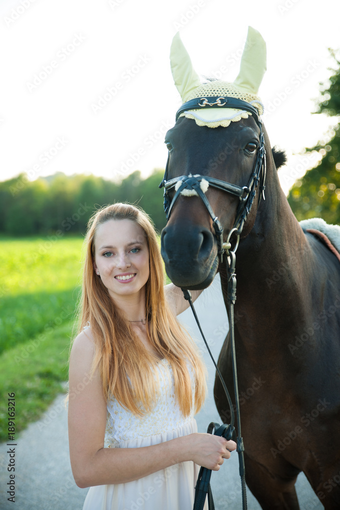 Obraz premium Beautiful young woman with horse outdoor on a walk in nature
