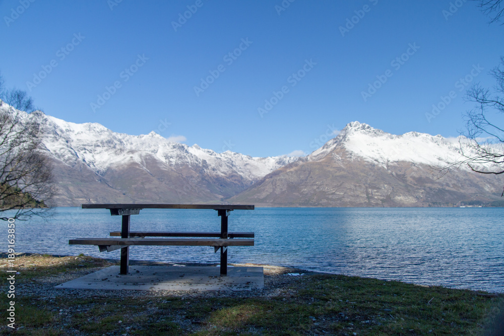 Sitzplatz am See mit schneebedeckten Bergen in Neuseeland nahe Queenstown Sitzplatz am See mit schneebedeckten Bergen in Neuseeland nahe Queenstown