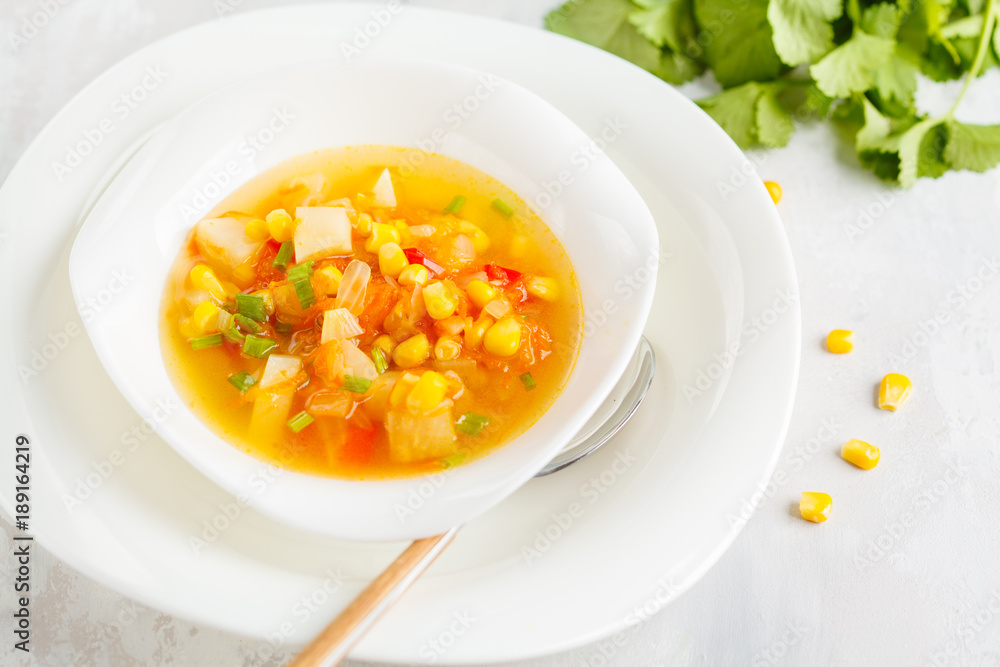 Healthy spring vegetable corn soup in a white plate. Vegan Healthy Food Concept. Top view Healthy spring vegetable corn soup in a white plate. Vegan Healthy Food Concept. Top view