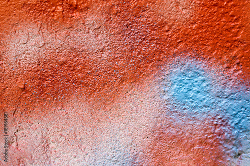Red and blue spray painted concrete wall as abstract texture background.
