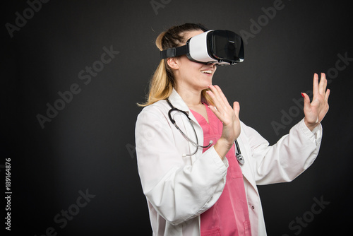 Female doctor wearing virtual reality glasses and gesturing
