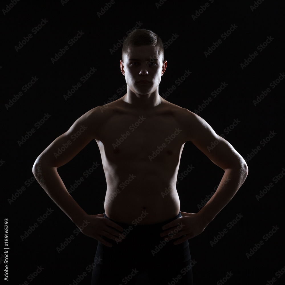 Naklejka premium The silhouette of the torso of a male athlete on a dark background.