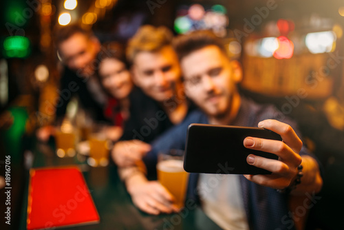 Happy football fans makes selfie at bar counter