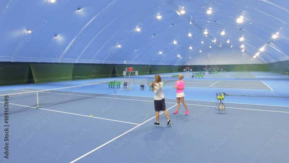 Woman-trainer teaches adult man to play tennis Woman-trainer teaches adult man to play tennis