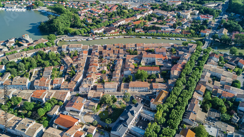 Aerial top view of Castelnaudary residential area houses roofs  streets and canal with boats from above  old medieval town background  France  