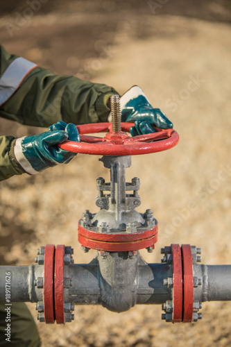 Oil worker is turning valve on the oil pipeline. photo