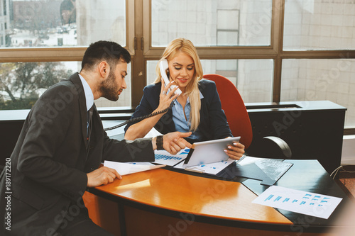 Businessman and businesswoman working with digital tablet in office