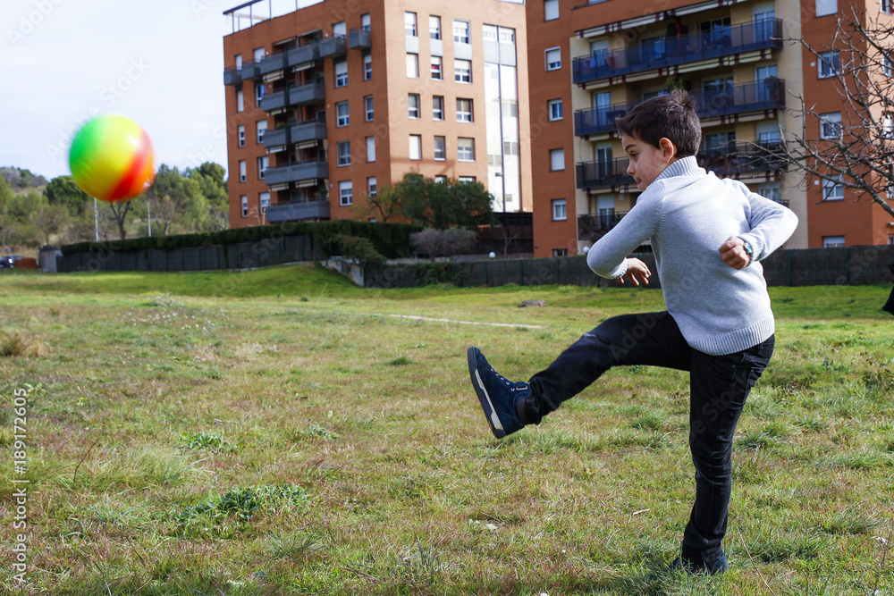 Fototapeta premium Boy kicking a ball