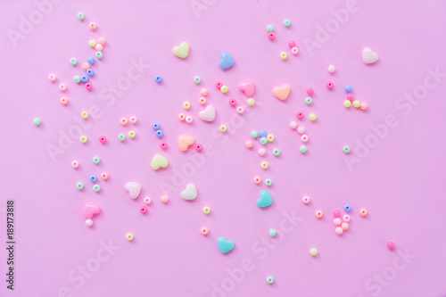 The 14th of February. St. Valentine's Day. Background with multicolored beads balls and hearts on a pink background. Top view with copy space