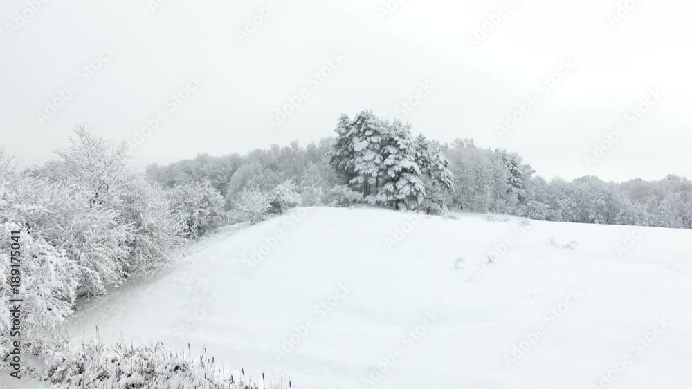 Aerial: Snow-covered countryside in winter Aerial: Snow-covered countryside in winter